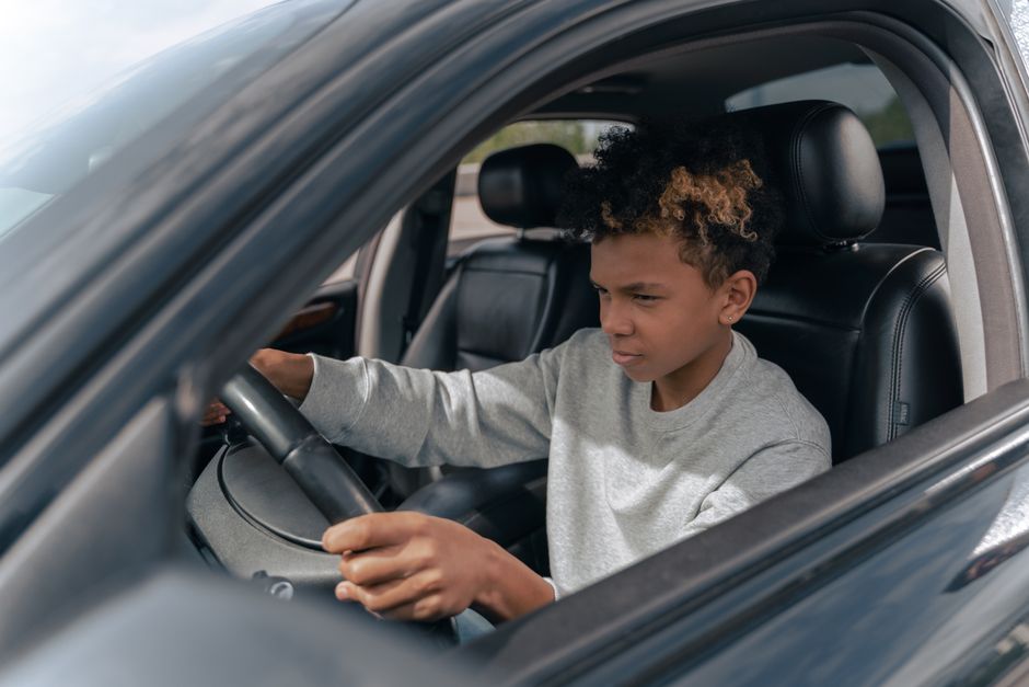 Een rijinstructeur geeft les aan een leerling in een auto, met focus op rijopleiding en kosten.
