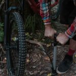 Een digitale fietspomp met drukmeter in gebruik bij een fiets, ideaal voor nauwkeurig oppompen.