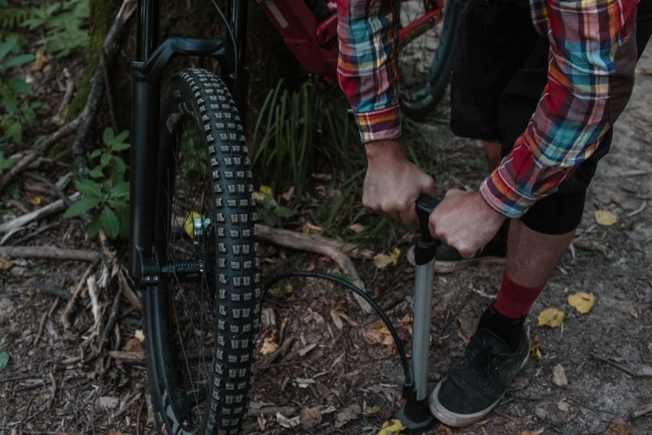 Een digitale fietspomp met drukmeter in gebruik bij een fiets, ideaal voor nauwkeurig oppompen.
